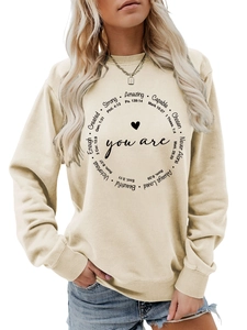 Detail des inspirierenden Buchstabendrucks und Herzmusters auf beigem Rundhals-Sweatshirt