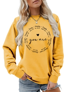 Detail des inspirierenden schwarzen Aufdrucks und Herzdesigns auf gelbem Sweatshirt