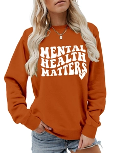 Detail of orange sweatshirt featuring white bold Mental Health Matters typography