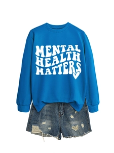 Detail of royal blue sweatshirt with Mental Health Matters print and ripped denim shorts