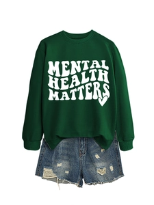 Detail of Mental Health Matters dark green sweatshirt with distressed denim shorts