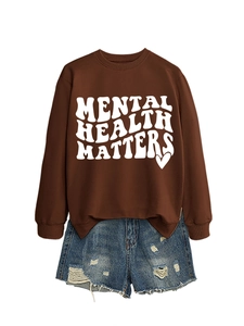 Detail of Mental Health Matters dark brown sweatshirt paired with distressed denim shorts