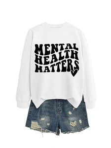 Flat lay of white long sleeve sweatshirt with Mental Health Matters print and denim shorts