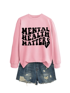 Flat lay of pink sweatshirt with Mental Health Matters print and distressed denim shorts
