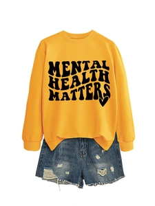 Close-up of yellow 'Mental Health Matters' sweatshirt paired with distressed denim shorts
