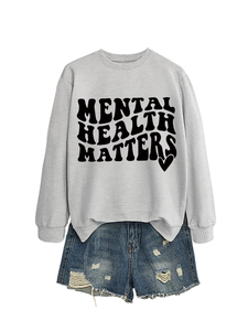 Detail of grey crewneck sweatshirt with black Mental Health Matters text and heart design