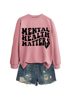 Flat lay of a pink Mental Health Matters sweatshirt and frayed blue denim shorts