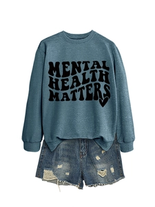 Detail of teal sweatshirt with Mental Health Matters print and frayed denim shorts