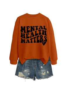 Detail of Mental Health Matters slogan printed on an orange crewneck sweatshirt