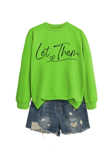 Detail of Let Them letter print on neon green sweatshirt with distressed denim shorts