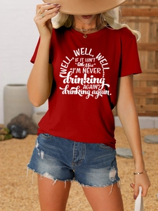 Outdoor lifestyle shot of red crew neck T-shirt with white slogan and denim shorts