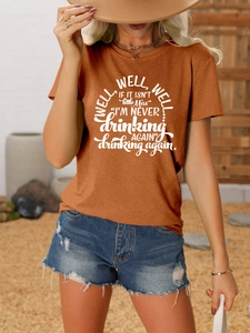 Detail of rust red cotton t-shirt featuring 'well well well' text and heart necklace