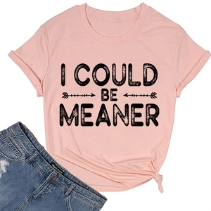 Détail du t-shirt en coton rose avec texte 'I COULD BE MEANER' et nœud latéral élégant
