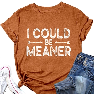 T-shirt orange rouille avec slogan posé à plat avec des baskets blanches et un jean