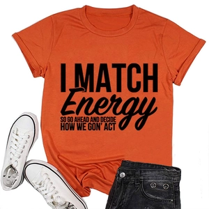 Gros plan du t-shirt orange à col rond avec texte imprimé noir et tenue de ville décontractée