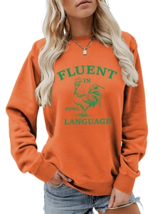 Gros plan sur les poignets côtelés et le tissu orange vif du sweat-shirt avec un coq
