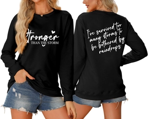 Detailed front and back view of black sweatshirt with white Stronger Than The Storm text
