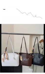 Three crocodile embossed tote bags in white, dark brown, and black with silk scarf decor