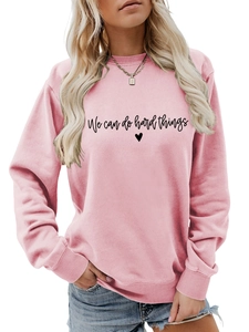 Gros plan du slogan We can do hard things et du cœur sur le sweat rose clair à col rond