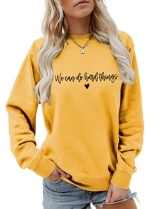 Détail du sweat-shirt jaune à col rond avec impression We can do hard things et coeur