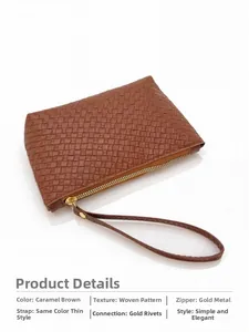 Detail of caramel brown woven leather texture with gold zipper and stylish wrist strap