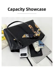 Capacity display of large black crocodile pattern handbag showing space for a tablet and umbrella