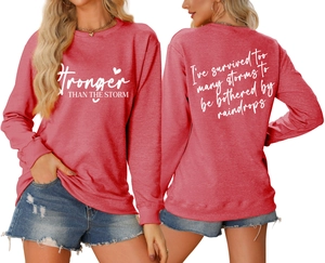 Front and back views of red crewneck sweatshirt with Stronger Than The Storm text