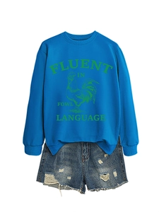 Détail du sweat-shirt bleu roi avec imprimé coq et short en jean bleu clair délavé