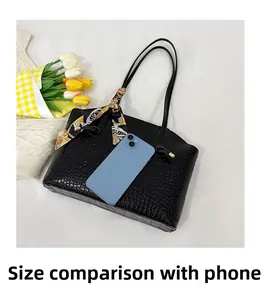 Detail of black crocodile texture tote bag with silk scarf and phone for size reference