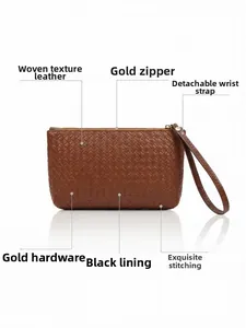 Detailed view of brown woven leather clutch with gold zipper and detachable wrist strap