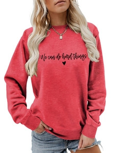 Détail de l'imprimé 'We can do hard things' sur un sweat-shirt rouge à col rond