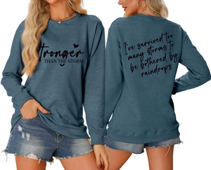 Detailed views showing the front and back inspirational prints on a teal oversized sweatshirt