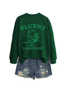Détail du sweat-shirt vert foncé avec imprimé de coq et short en jean vieilli