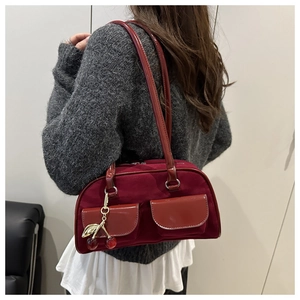 Detail of burgundy shoulder bag with suede拼接 and cherry charm decoration