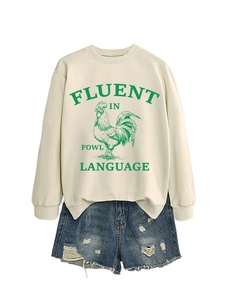 Détail du sweat blanc avec imprimé coq et short en jean bleu délavé à déchirures