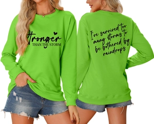 Detail of Stronger Than The Storm lettering on a bright green casual sweatshirt