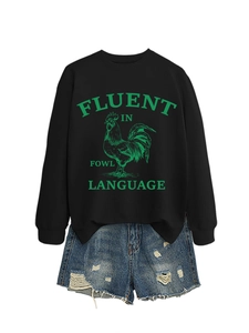 Détail d'un sweat noir avec imprimé coq et d'un short en jean bleu délavé usé