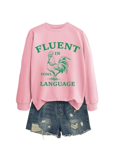 Détail d'un sweat rose avec motif coq et d'un short en jean posé à plat