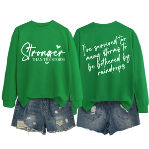 Front and back view of green crewneck sweatshirt with Stronger Than The Storm print
