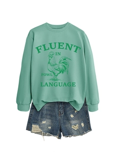 Détail du sweat-shirt vert menthe avec imprimé coq et texte Fluent in Fowl Language