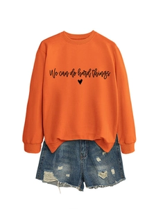 Détail du sweat orange avec imprimé We Can Do Hard Things et fentes latérales élégantes