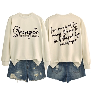 Front and back detail of a beige sweatshirt featuring Stronger Than The Storm text print