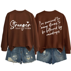 Front and back view of brown sweatshirt with Stronger Than The Storm text and heart print