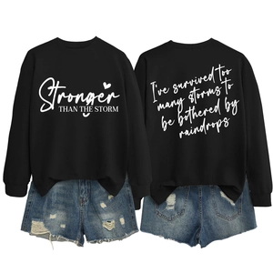 Detailed flat lay of black sweatshirt with back slogan and distressed denim shorts