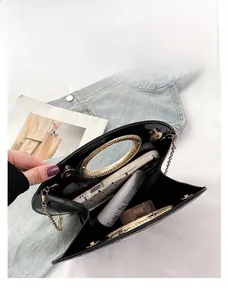 Detail view of the black glossy leather handbag interior showing storage capacity
