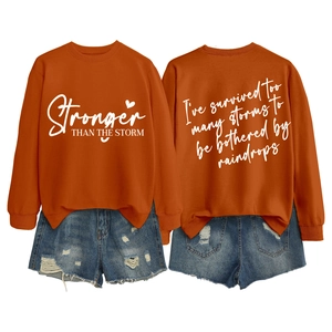 Detail of burnt orange sweatshirt showing front and back motivational text prints