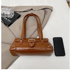 Détail du sac à main rétro marron avec rivets métalliques argentés et boucle de ceinture