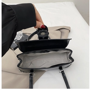 Vue intérieure du sac bandoulière noir avec doublure grise et fermoir magnétique argenté