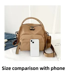 Detailed comparison of khaki nylon shoulder bag size with a smartphone for scale
