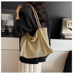 Gros plan d'un sac cabas tissé ajouré avec bordure en cuir sur l'épaule d'un mannequin